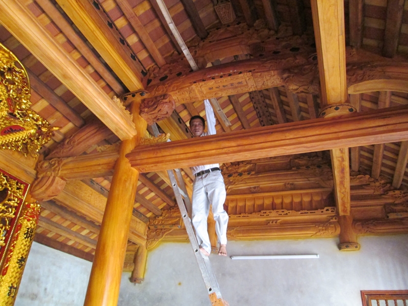 Hình ảnh người thợ gác thước tầm lên nóc nhà gỗ (nguồn internet)